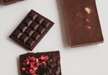 Milk chocolate pieces isolated on white background from top view