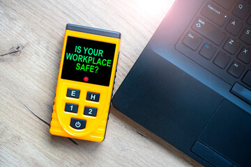 Electromagnetic radiation concept with text Is your workplace safe on the tester lying near the notebook.
