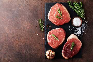 Raw fresh beef meat on slate black plate. Top view flat lay with copy space