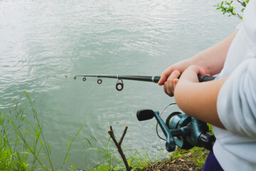 fishing rod in hands near the river