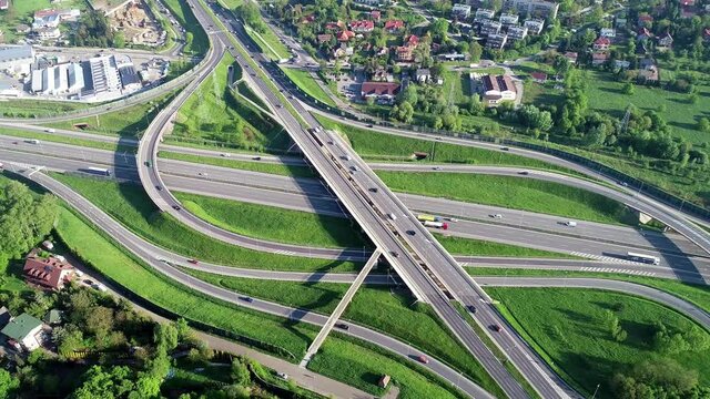 Motorway multilevel crossing. Spaghetti junction on A4 international highway, the part of orbital road around Krakow, Poland. Aerial 4K revealing video in spring