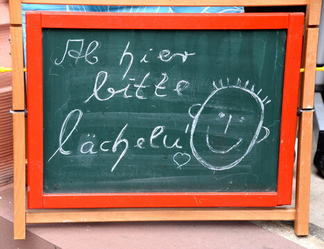 Kreidetafel: "Ab hier bitte l&auml;cheln."