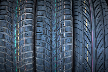 New rubber tires for car wheels stacked next to each other, close-up. Background from car tires.