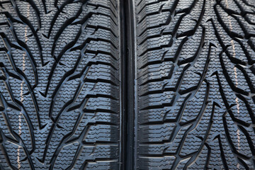 New rubber tires for car wheels stacked next to each other, close-up. Background from car tires.