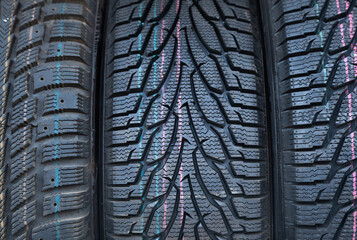 New rubber tires for car wheels stacked next to each other, close-up. Background from car tires.