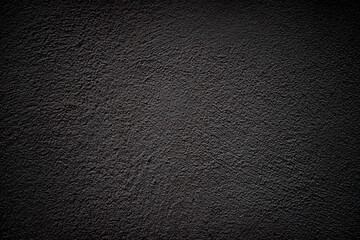 Black grunge background with vignette. Plaster texture.