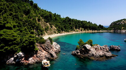 Drone aerial view of tourists enjoying a paradise luxury Yacht trip around Skopelos island, Greece, Aegean Sea, Europe.