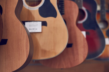 A range of new acoustic guitars in a store.