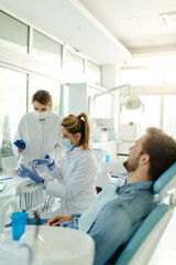 Obraz premium The female dentist and the assistant prepare the instruments for the dental examination.