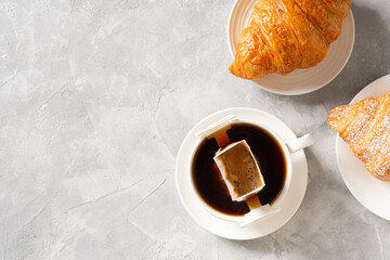 Cup of coffee with drip filter and croissant
