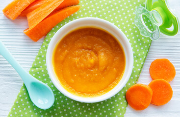 Baby carrot mashed with spoon in bowl
