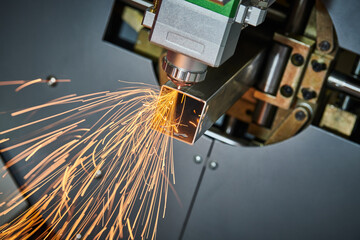 Laser cutting of metal pipe with sparks on tube laser machine