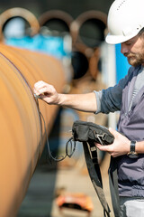 Obraz premium Technician is testing to welds of pipe with ultrasonic test method. It is a family of non-destructive testing techniques based on the propagation of ultrasonic waves in the object or material tested.