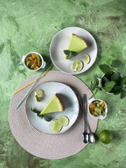 Composition with lemon cheesecake  green art background, top view, copy space.
