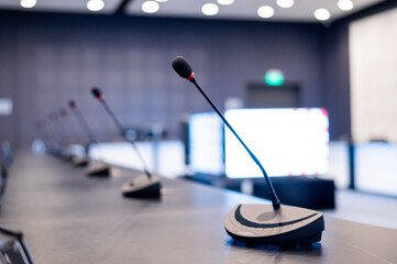 Close-up of microphones in an empty meeting room at a press conference.