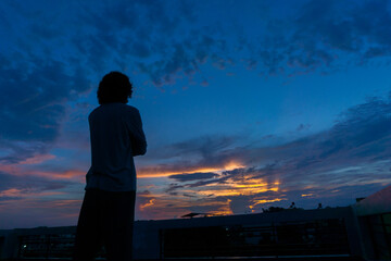 Fototapeta premium A person looking at the evening sky at dusk.
