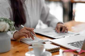 Close up woman using computer calculating finance or taxes on machine, female manage home family...