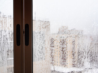 frozen window in urban house in city in winter