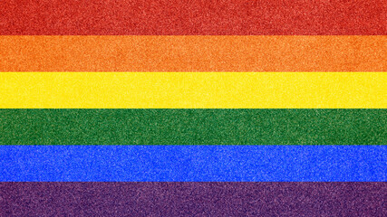 The rainbow flag (a symbol of lesbian, gay, bisexual, transgender, and queer pride) over a glitter texture.
