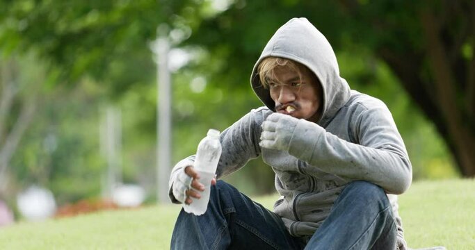 Homeless man drinking and eating food