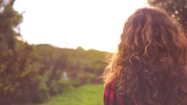 alone in the park - girl walking in the park stops, turns and stare at camera