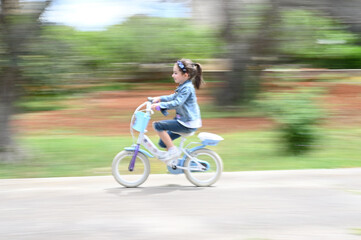 Ritratto di una bambina di sette anni alla guida della sua bicicletta.