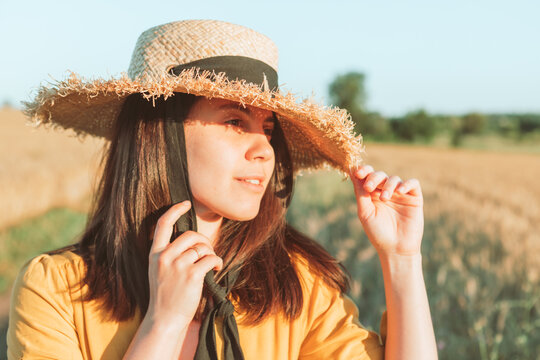 Woman In Yellow Sundress Walking By Wheat Field