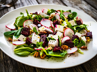  Beets salad with feta cheese on wooden background
