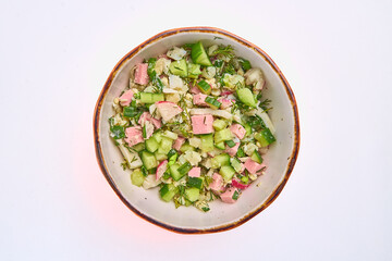 Okroshka salad of boiled eggs, sausage and potatoes, fresh cucumber, green onions, radish and dill...