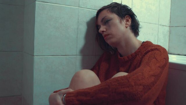 mental disorders - depressed girl sitting on the floor with catatonic look