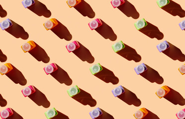 Pattern of sunscreen bottles on orange background