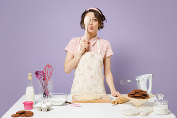 Young fun amazed housewife housekeeper cook chef baker woman in pink apron work at table...