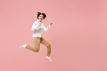 Fototapeta na wymiar Full length young successful employee business woman corporate lawyer in classic formal white shirt work in office jump high point index finger aside on copy space isolated on pastel pink background