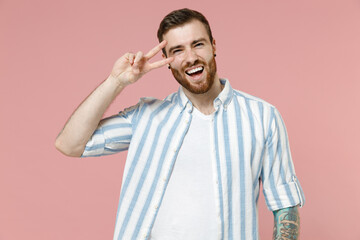 Young happy smiling friendly caucasian unshaven man 20s in blue striped shirt white t-shirt cover...