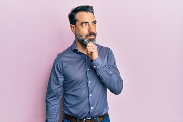 Middle age man with beard and grey hair wearing business clothes with hand on chin thinking about...