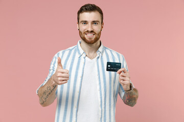 Young smiling fun rich satisfied happy caucasian unshaven man in blue striped shirt hold credit...