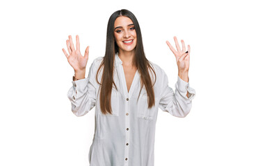 Young beautiful woman wearing casual white shirt showing and pointing up with fingers number nine while smiling confident and happy.