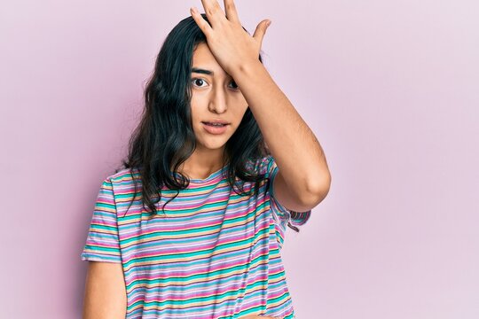 Hispanic teenager girl with dental braces wearing casual clothes surprised with hand on head for mistake, remember error. forgot, bad memory concept.