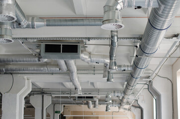 Air duct, air conditioner pipe on white ceiling wall. Ventilation system on the ceiling of large...