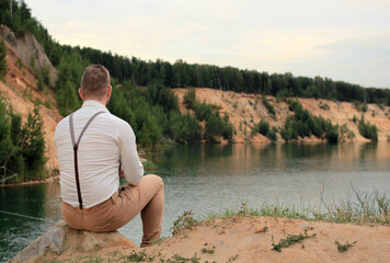 Fototapeta premium Person sitting on the shore