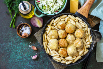 Italian pasta. Spaghetti with meatballs in cheese sauce on a dark  stone or concrete background. Top view, flat lay background. Copy space.