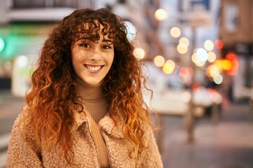 Young hispanic woman smiling happy standing at the city