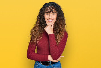 Young hispanic girl wearing casual clothes looking confident at the camera smiling with crossed arms and hand raised on chin. thinking positive.