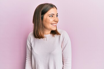 Fototapeta premium Young beautiful woman wearing casual clothes looking away to side with smile on face, natural expression. laughing confident.
