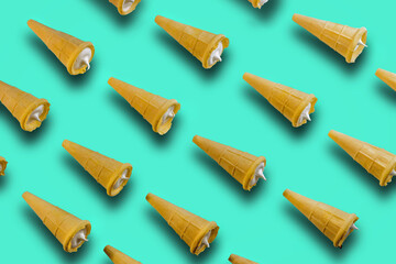 Waffle cones with filling on a green background. Image of a sweet treat. Sweet waffle cones with white filling.