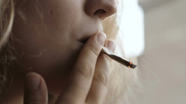 addiction, tobacco - young woman eagerly sucks a cigarette - macro