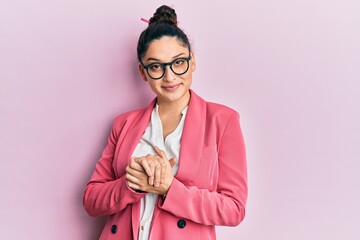 Beautiful middle eastern woman wearing business jacket and glasses with hands together and crossed fingers smiling relaxed and cheerful. success and optimistic