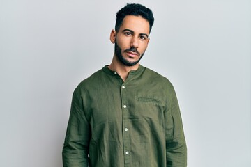 Young hispanic man wearing casual clothes relaxed with serious expression on face. simple and natural looking at the camera.