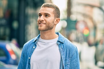 Young caucasian man smiling happy standing at the city.