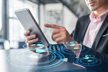 Businessman in suit using tablet device to optimize development by implying new technologies in...